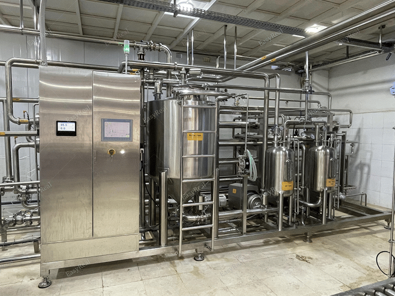 Skid-mounted stainless steel UHT/HTST sterilization system with control cabinet, balance tank, heat exchangers and sanitary piping, designed for continuous thermal treatment of carrot juice and carrot puree.