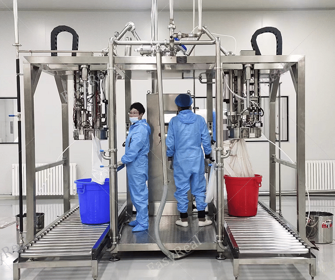 Two-head aseptic bag filling machine with roller conveyor and operators in cleanroom suits, filling carrot puree or concentrated carrot juice into sterile bag-in-drum packages at the end of the processing line.