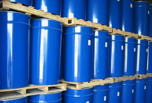 Stacks of blue 200L drums on pallets, used for aseptic bulk packaging of carrot puree or concentrated carrot juice from industrial processing lines.