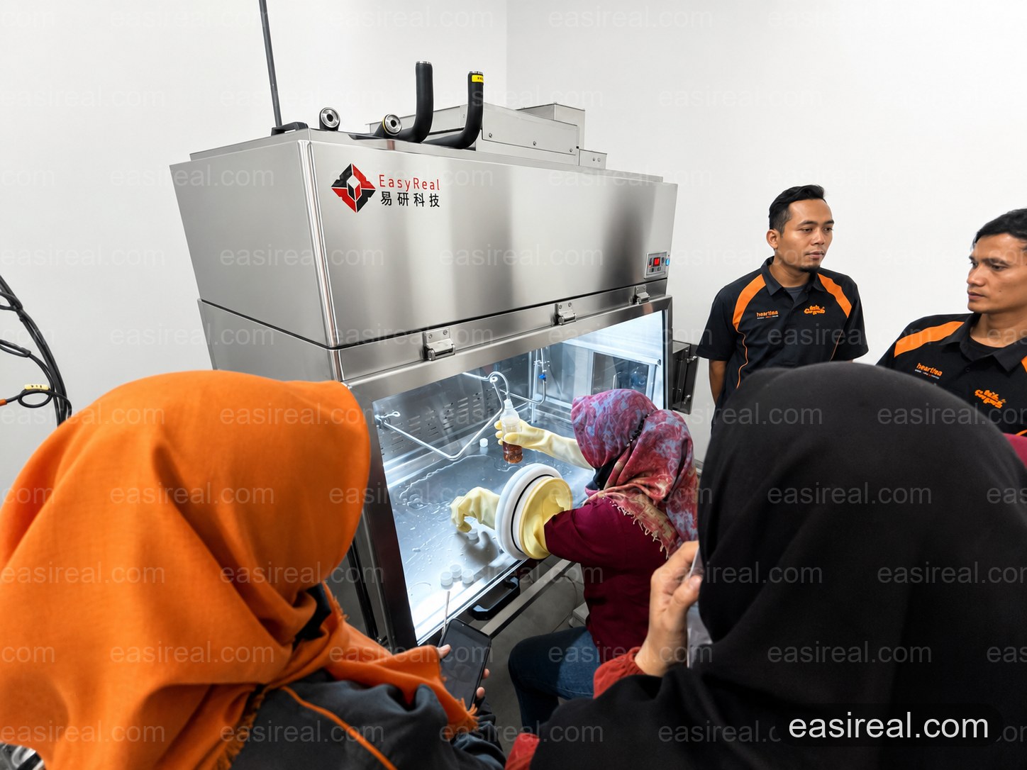 WELLTRAS team learning aseptic sample filling in the EasyReal pilot filling cabinet WELLTRAS team learning aseptic sample filling in the EasyReal pilot filling cabinet