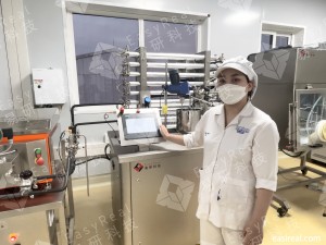 Close-up of an INTERBOS R&D operator operating an EasyReal pilot UHT/HTST system with tubular heat exchanger and touch-screen control in the Vietnam lab